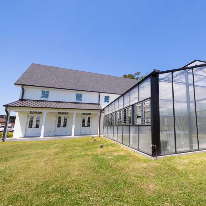 white building with a green house next to it